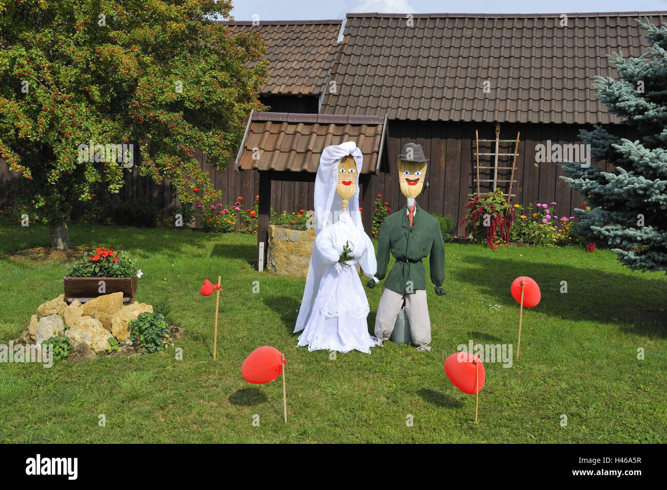 wooden hut, garden, scarecrows, meadow, scarecrow couple, clothing, care, suit, wedding dress, broom, dolls, 'wedding couple', scare away, deterrence, balloons, red, hut, trees, fruit-tree, fir, flowers, sunshine, Stock Photo