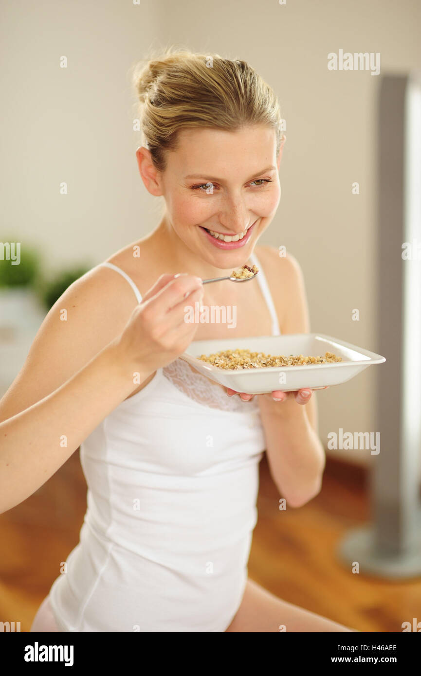 Young woman is eating muesli, happy Stock Photo Alamy