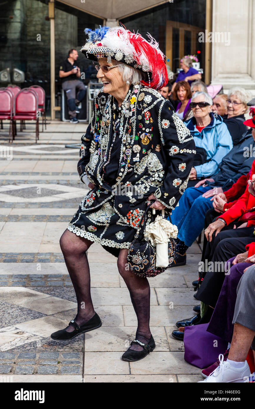 A Pearly Queen Does A Jig At The Pearly Kings and Queens' Harvest Festival, Held Annually At The Guildhall Yard, London, England Stock Photo
