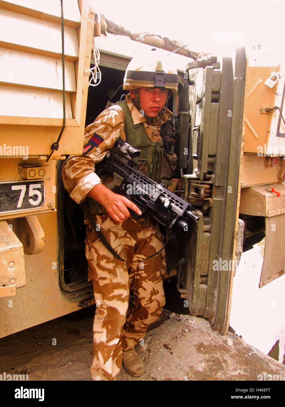 13th April 2003 A British soldier of the Irish Guards exits the back door of a Warrior fighting vehicle in Basra, Iraq. Stock Photo