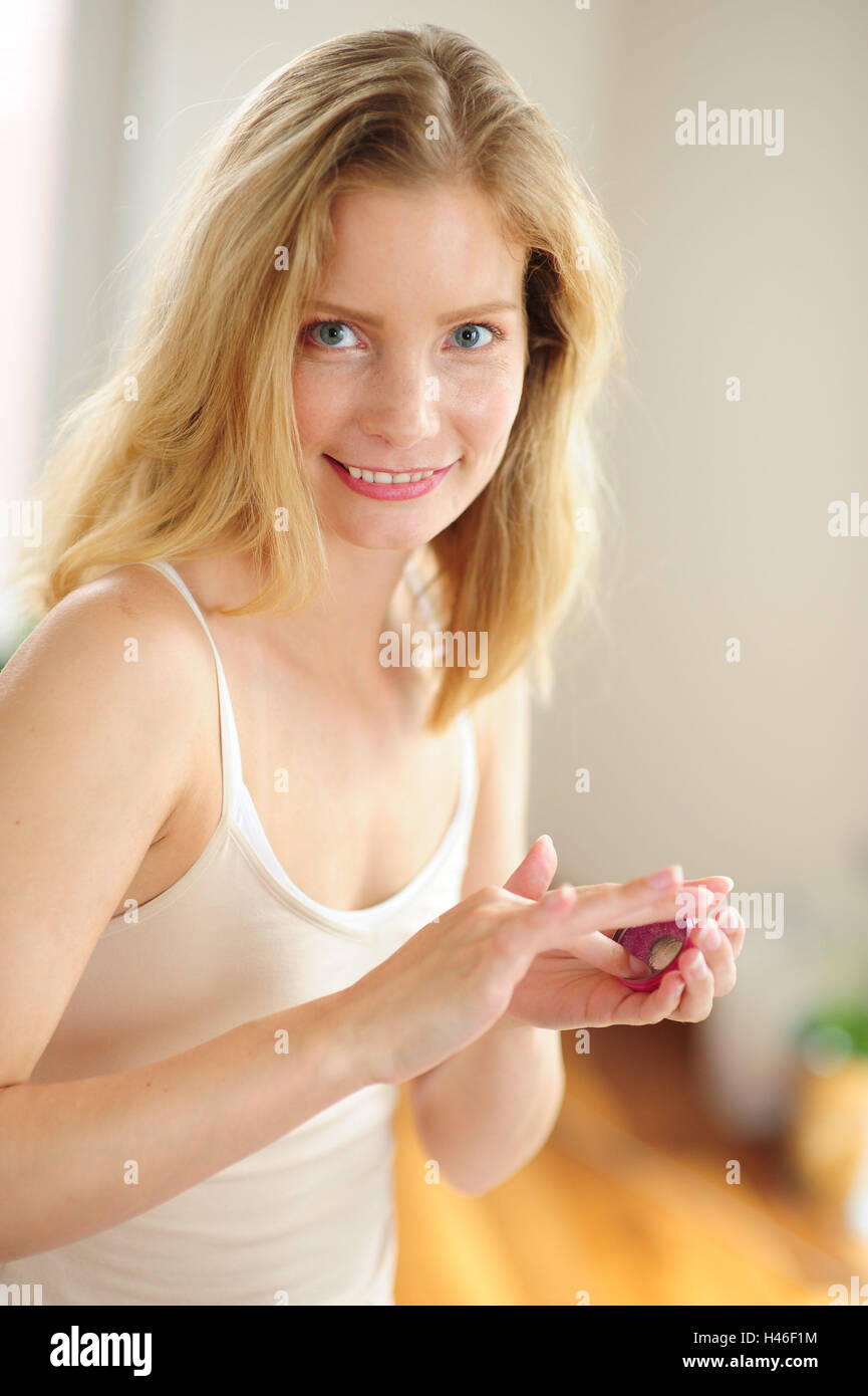 Young woman is holding lip balm in the hand Stock Photo