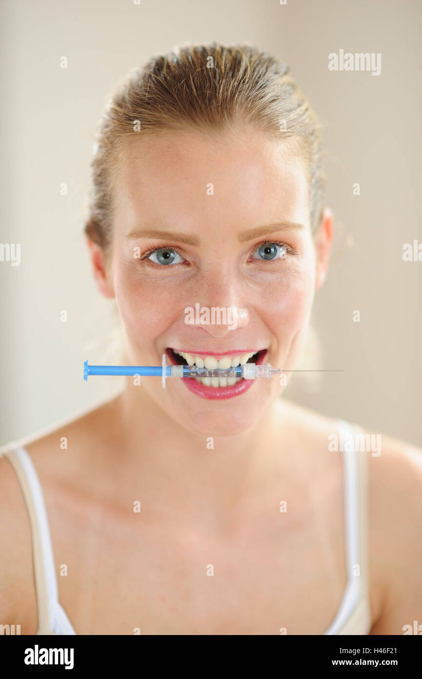 Woman is holding syringe in his mouth, happy Stock Photo Alamy