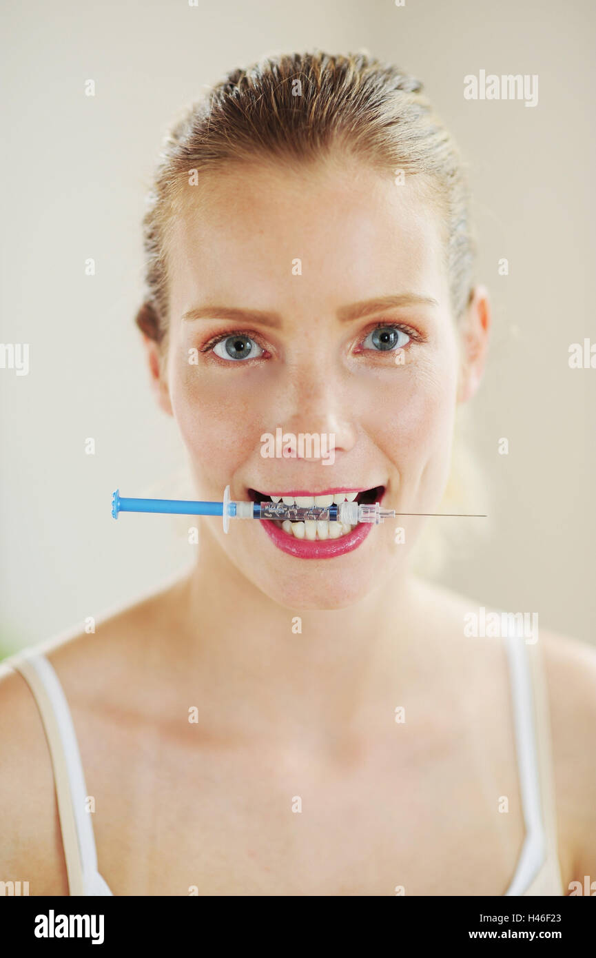 Young woman with syringe in the mouth Stock Photo Alamy
