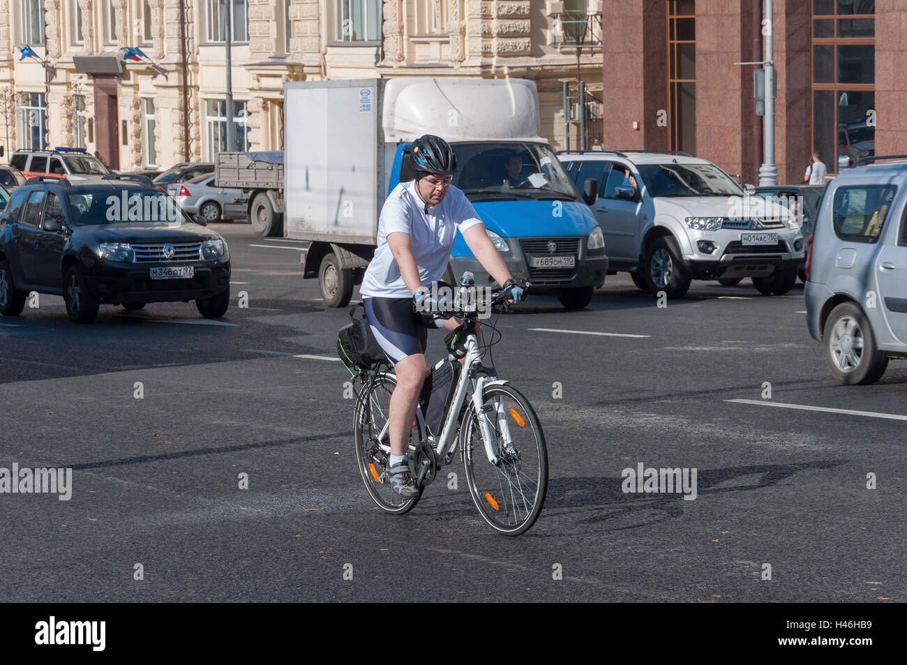 Moscow, Russia- 21.09.2015. Man on bike rides in traffic on Theatre Street Stock Photo
