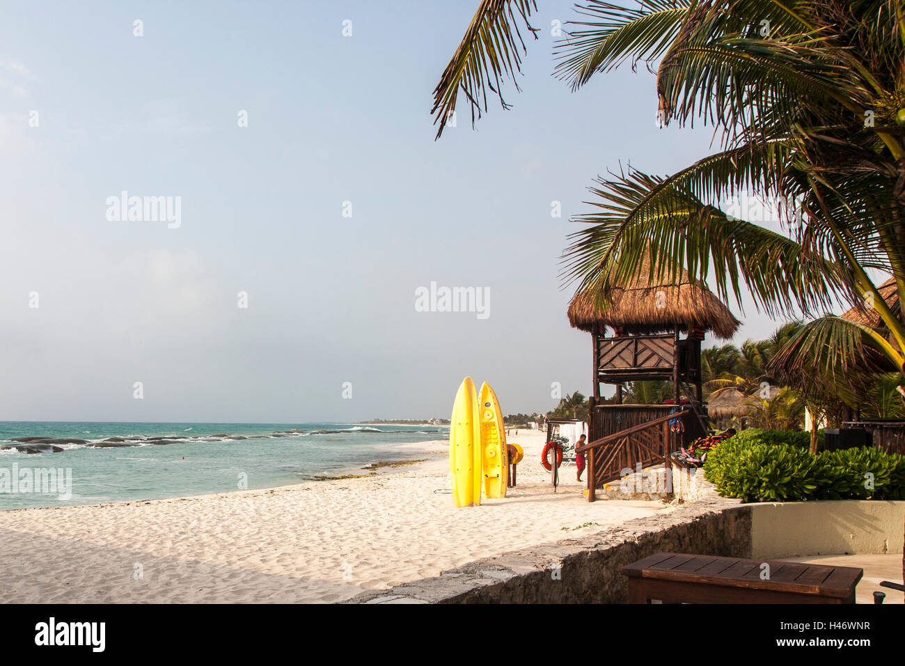 Beach tiki hut with Yellow Kayaks and palm trees Stock Photo