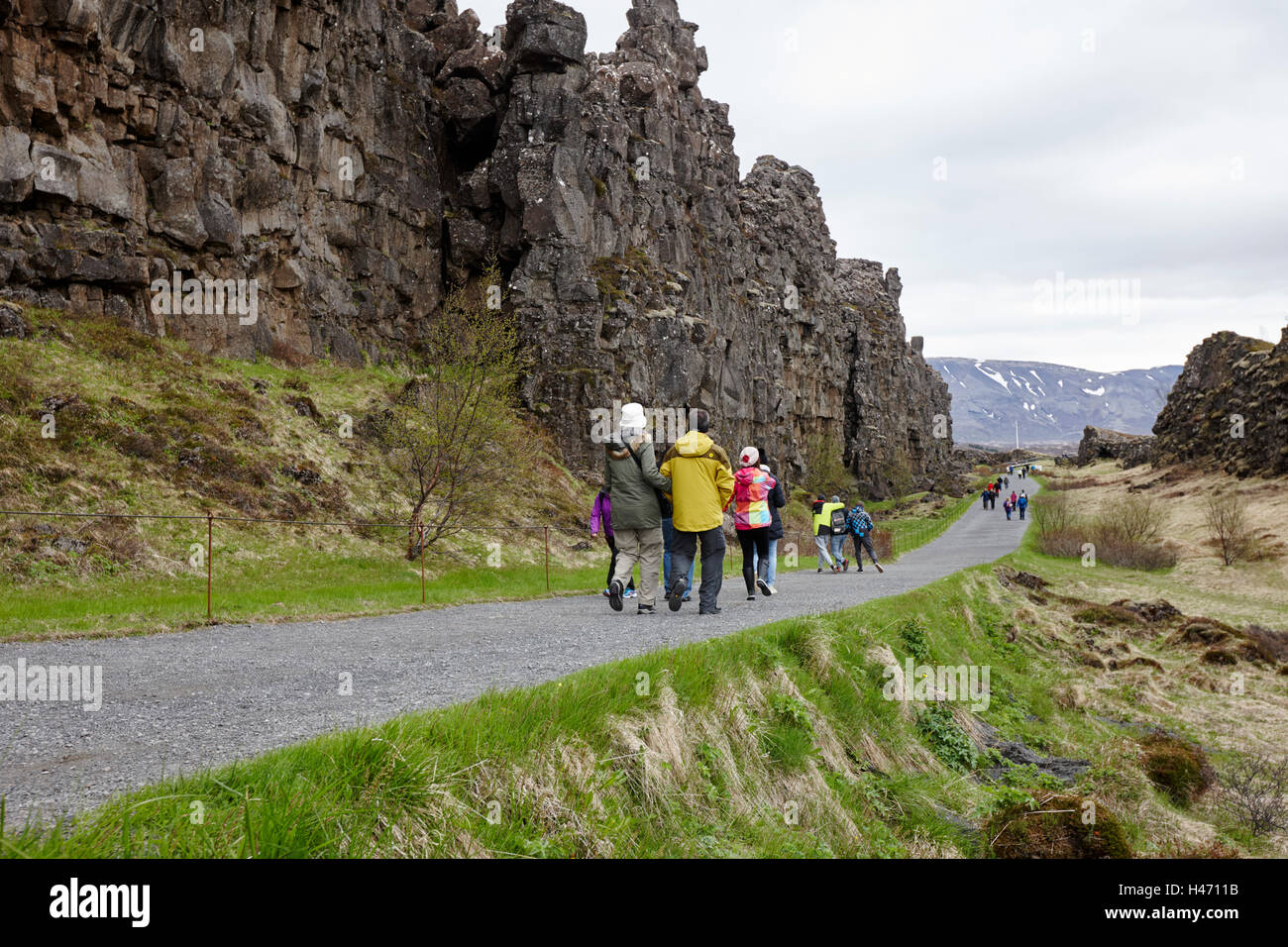 people walking through fissures in the continental plates at thingvellir national park Iceland Stock Photo