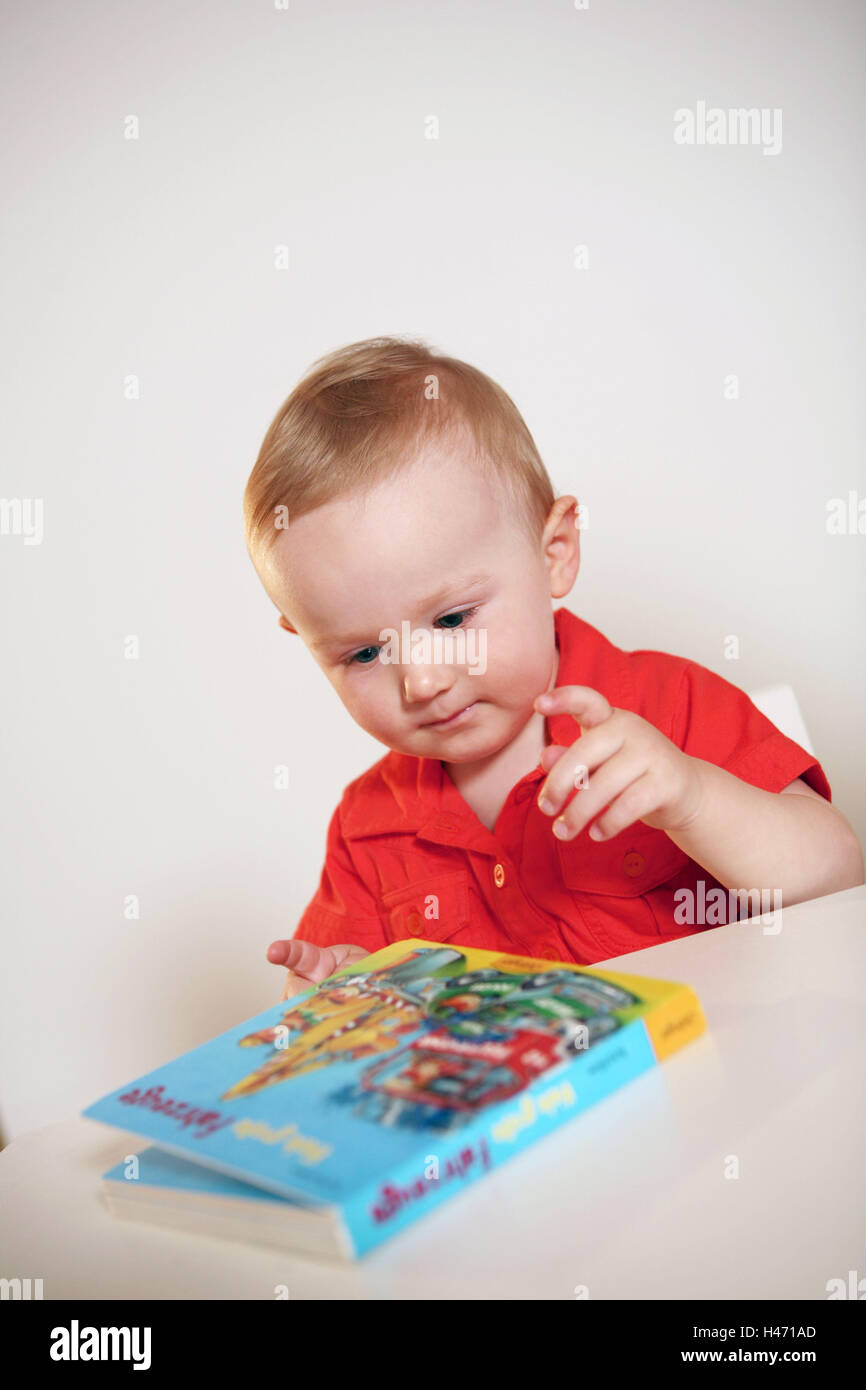 Infant, boy, picture book, portrait, person, child, alone, sit, look at table, at toys, educationally, brightly, child literature, book, children's book, pictures, interest, development, learn, indicate, recognise, understand, discover, abilities, skill, activity, inside, Stock Photo