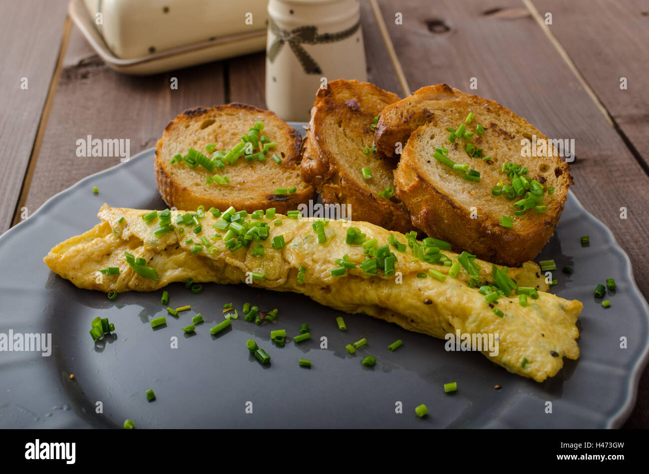 French omelette with chives, fresh herbs and garlic toast Stock Photo