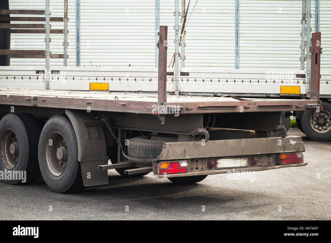 Rear fragment empty truck cargo trailer on asphalt road Stock Photo
