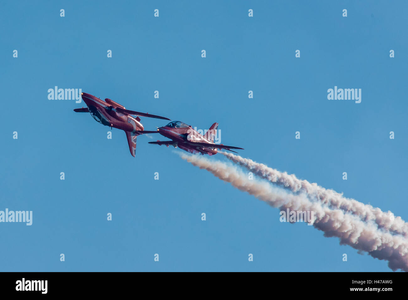 Two of the Red Arrows RAF display team in a low pass, one inverted. Stock Photo