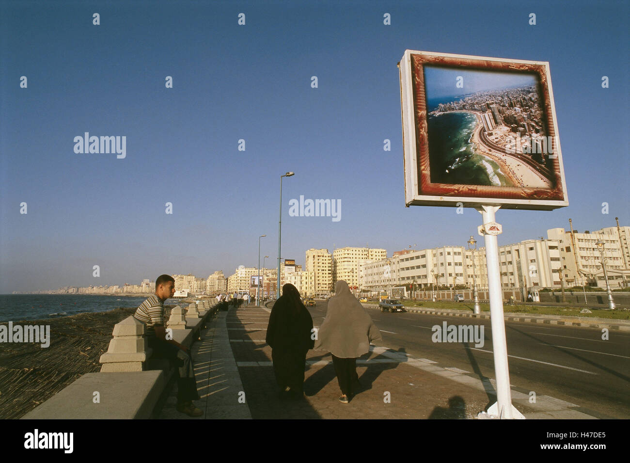 Egypt, Alexandria, Corniche, Uferstrasse, promenade, sign, coastal overview, passer-by, sea, Nordostafrika, coast, port, town, town view, street, bank promenade, high rises, traffic, person, pedestrian, advertising signs, advertising notice board, east harbour, harbour, Mediterranean coast, the Mediterranean Sea, Stock Photo