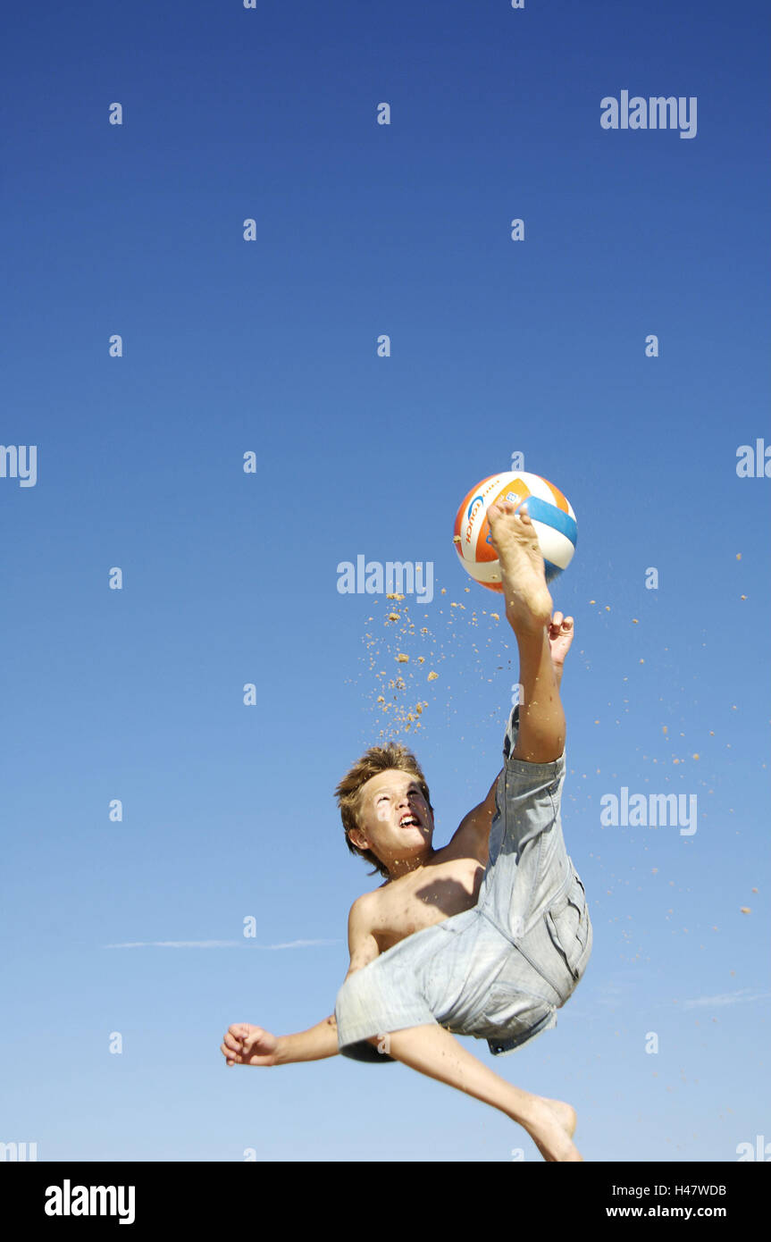 Boy playing with ball on the beach, jump, Stock Photo