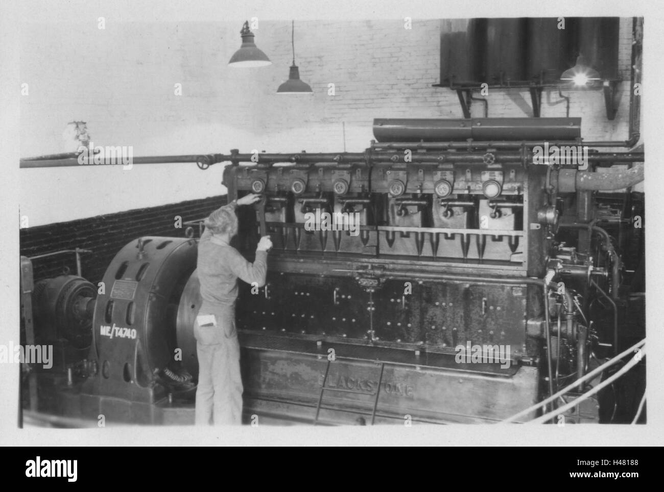 Unidentified army engineer tending to a Blackstone diesel generator. Photo taken in 10 Base Ordnance Depot Royal Army Ordnance Corps (RAOC) camp at Geneifa Ismailia area near the Suez Canal 1952 Egypt Stock Photo