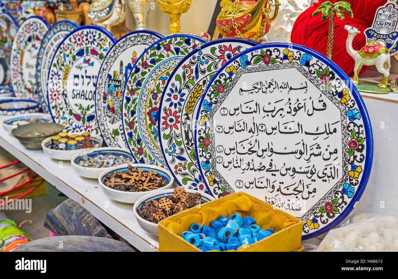 The colorful plates with floral ptterns, wishes good luck, Surahs from Quran are traditional souvenirs in Arab market, Jerusalem Stock Photo