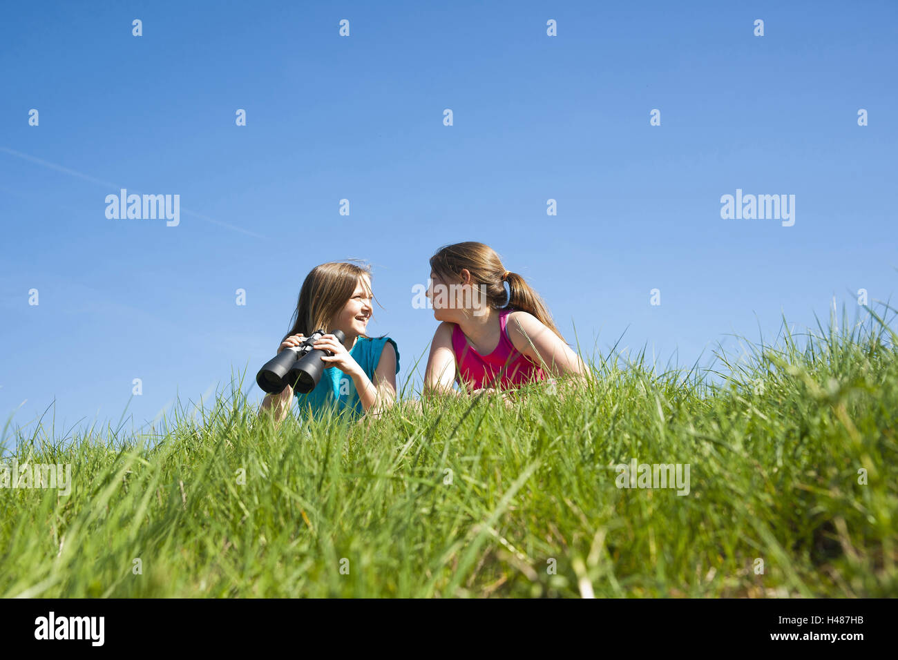 two girls observe the nature with binoculars, Stock Photo