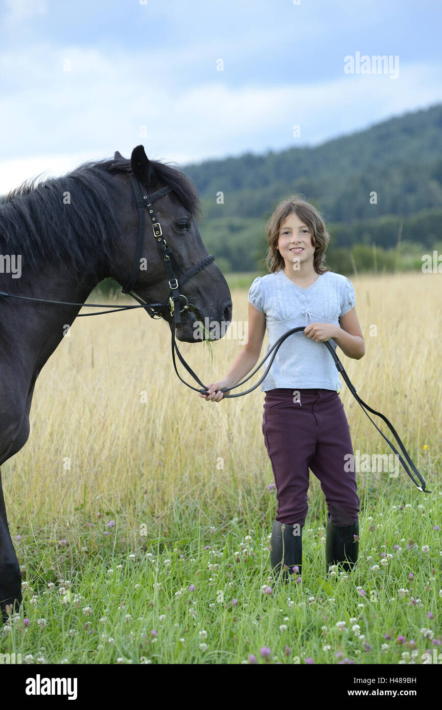 Girl, horse, meadow, standing, looking at camera, landscape, Stock Photo