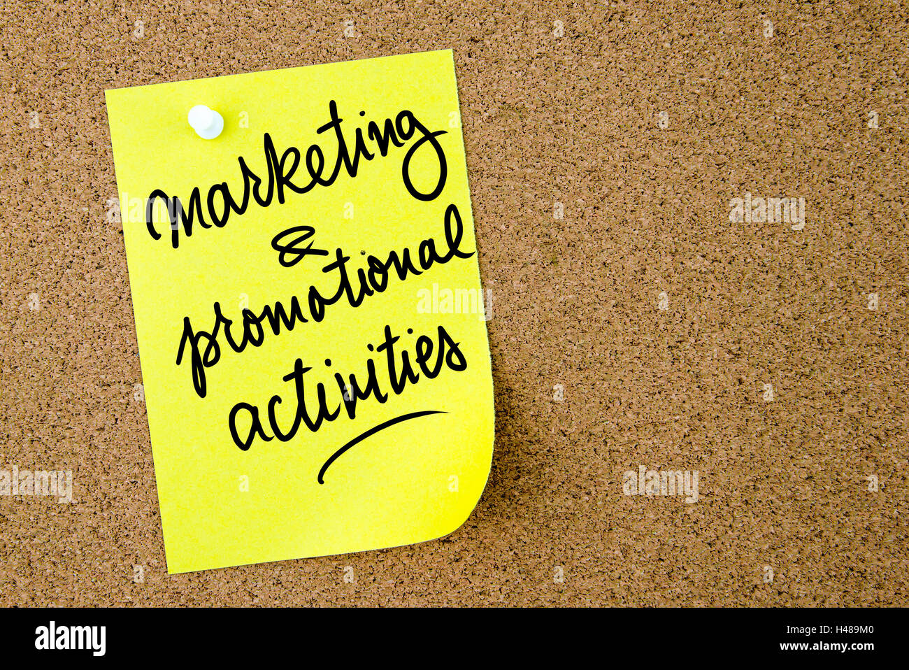 Marketing and Promotional Activities text written on yellow paper note pinned on cork board with white thumbtack. Stock Photo