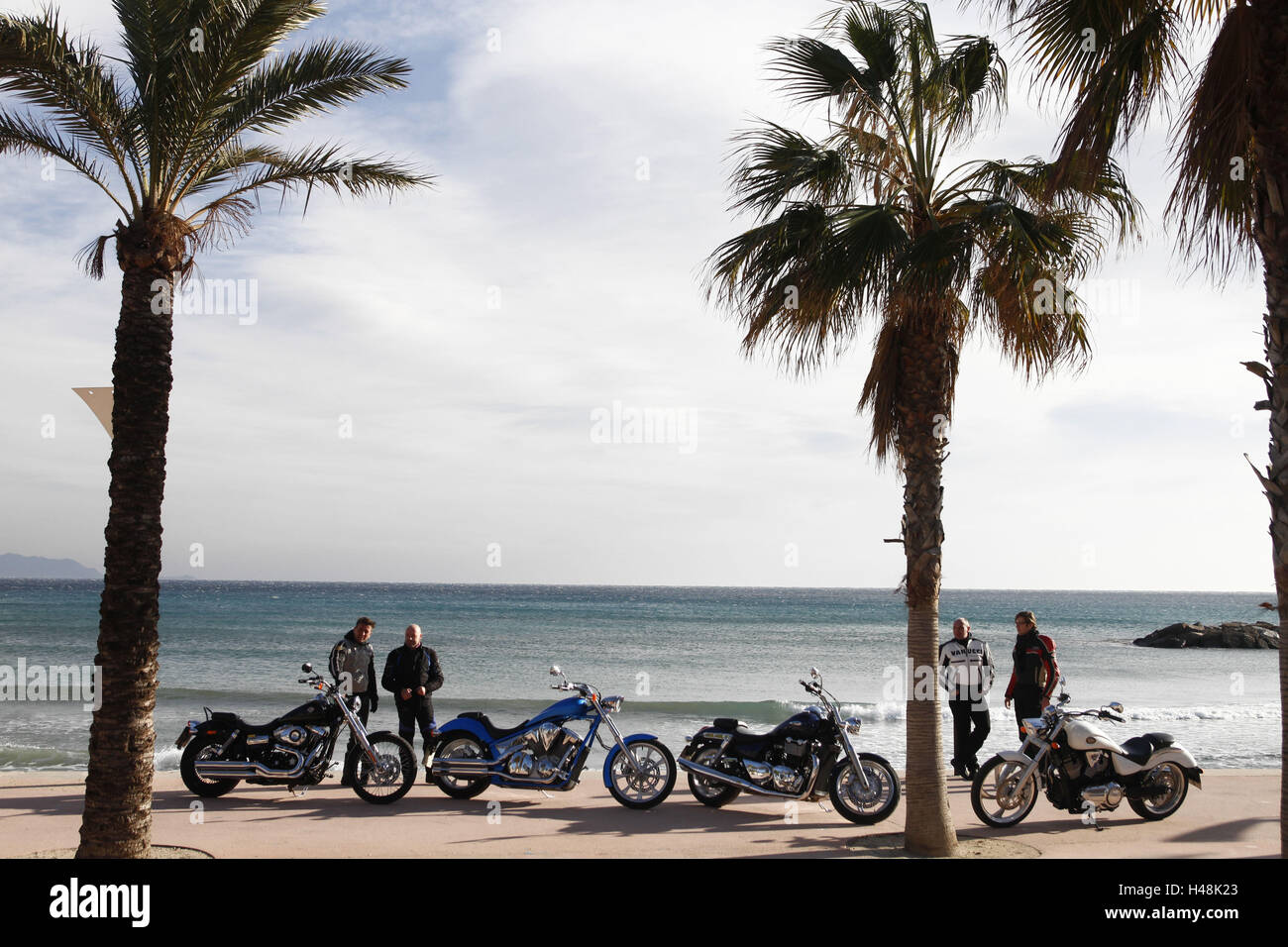 four motorcycles, cruisers, beach, palms, South of France Stock Photo
