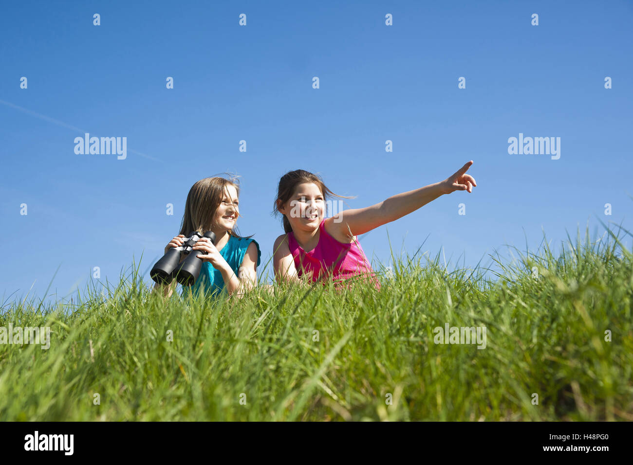 two girls observe the nature with binoculars, Stock Photo