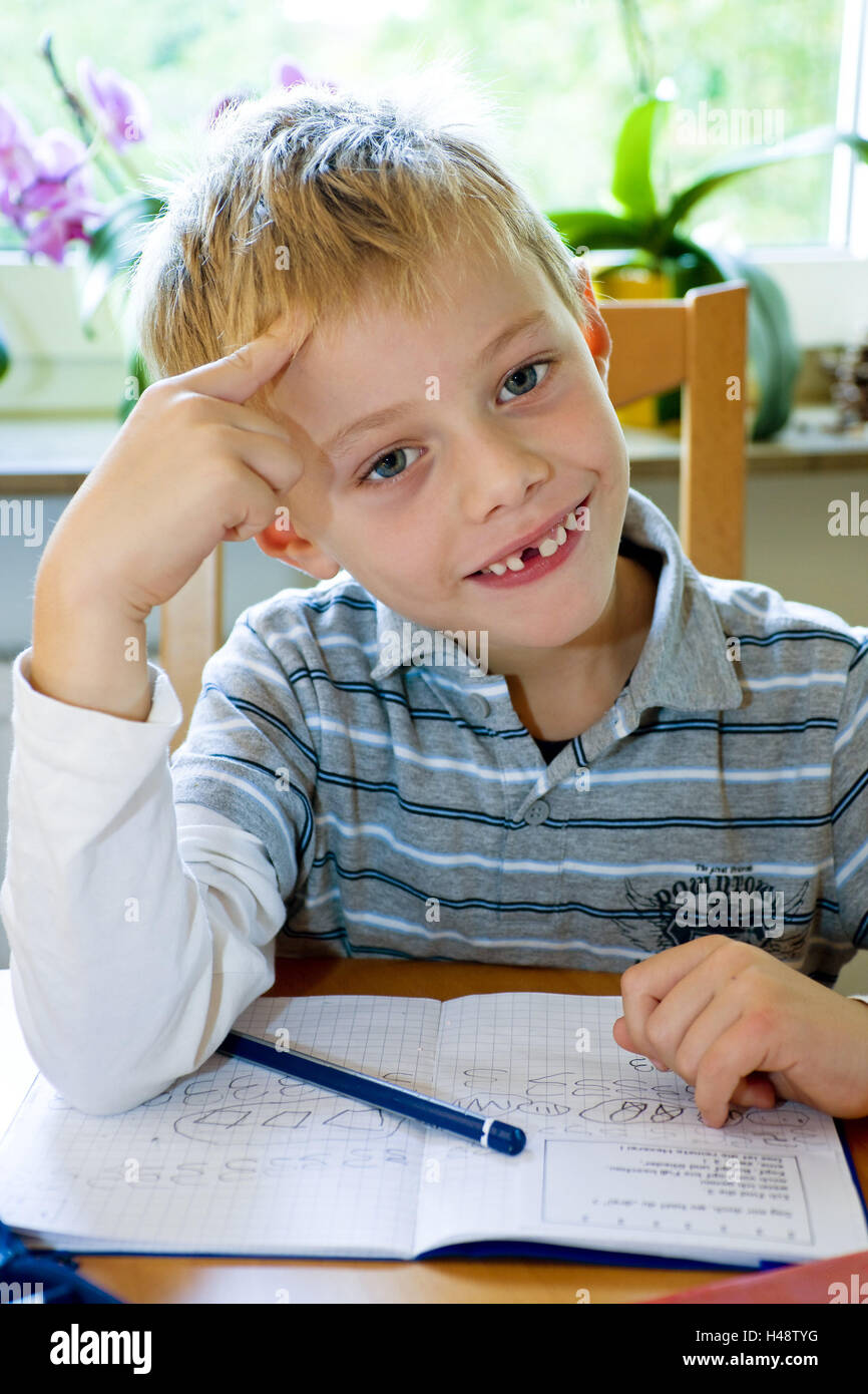 Boy, 6 years, view camera, smile, learn homework, model released, school beginner, school child, first grader, atomic, biological and chemical scorer, child, person, exercise book, notebook, pencil, pen, figures, exercises, writing exercises, write, portr Stock Photo