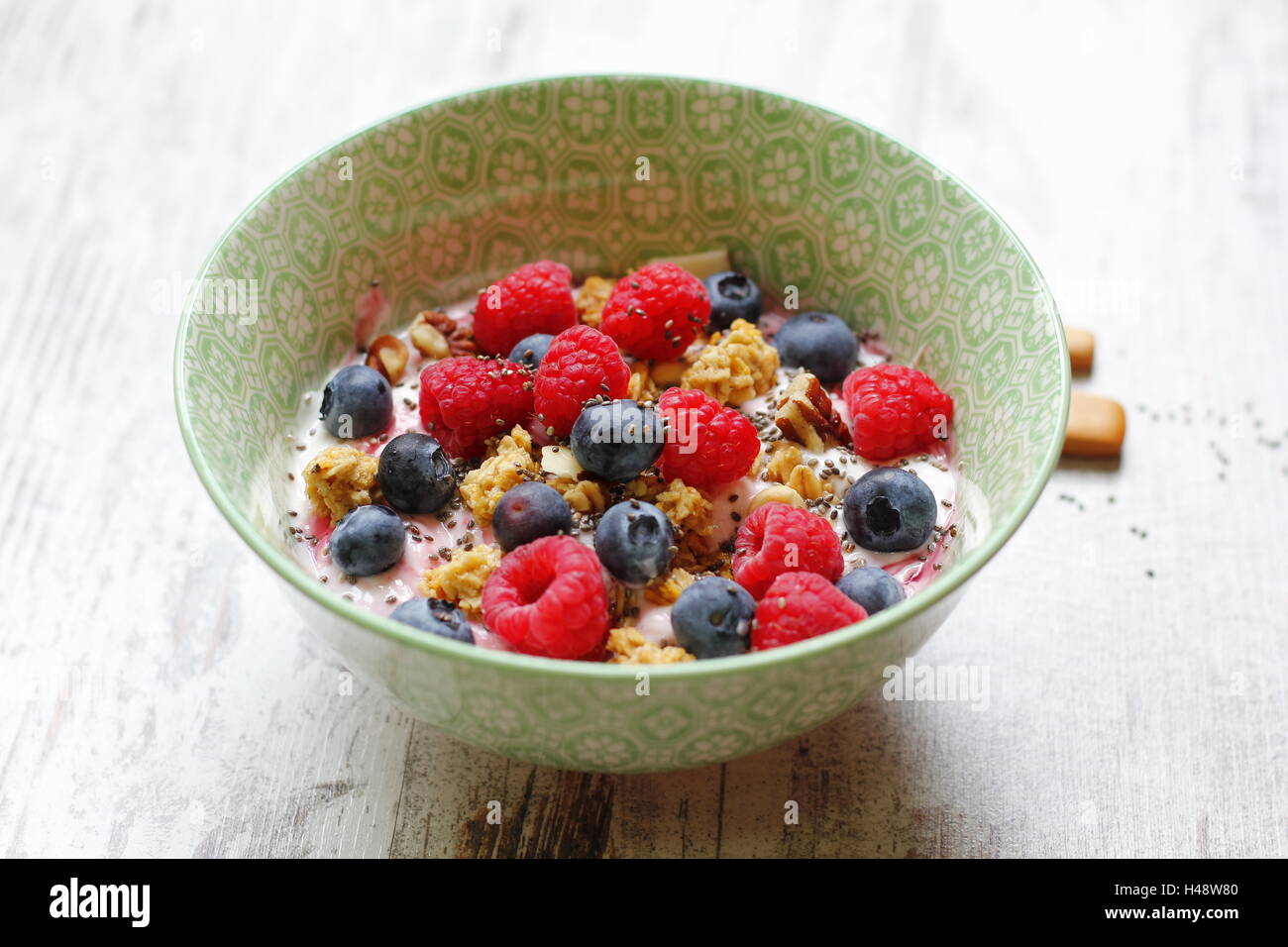 Fresh fruit with muesli and yogurt, in a ceramic bowl Stock Photo
