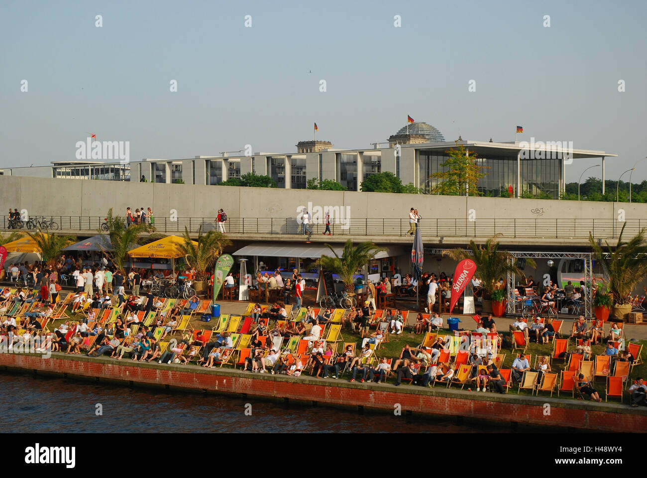 Germany, Berlin, Spree bow, beach cafe, deck chairs, people, town, capital, the Spree, river, riverside, summer, solar bath, guests, tourists, sun benches, take it easy, recreation, rest, leisure time, Reichstag dome, Stock Photo