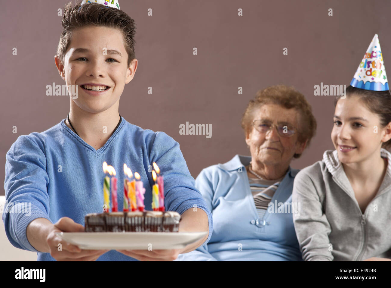 Grandson and granddaughter celebrate with her grandmother birthday, Stock Photo