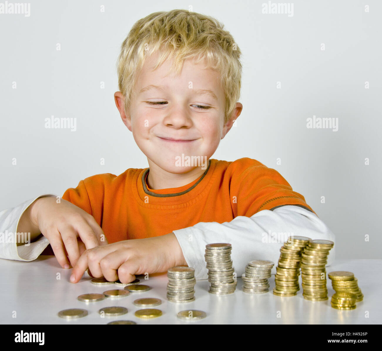 Boy, sit, money, count, monetary towers, model released, people, child, blond, view, roguishly, smile, build hard money, coins, euro, euro coins, euro coins, coin money, hard money, towers, pocket money, save, count, finances, portrait, Stock Photo