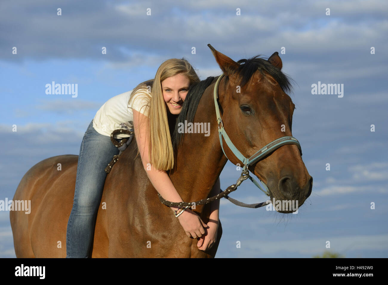 Teenage girl, rider, horse, back, lie, embrace, scenery Stock Photo Alamy