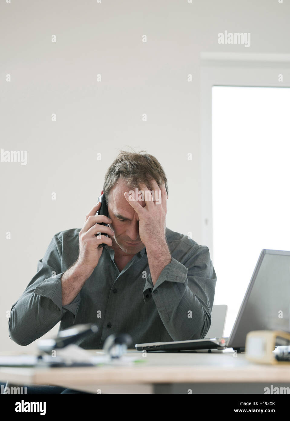 Man sits desperately in front of his laptop, Stock Photo