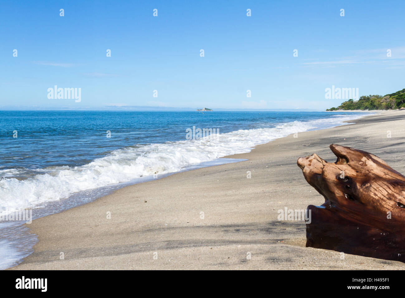 relaxing beach with blue water and layers of white and black sand in ...