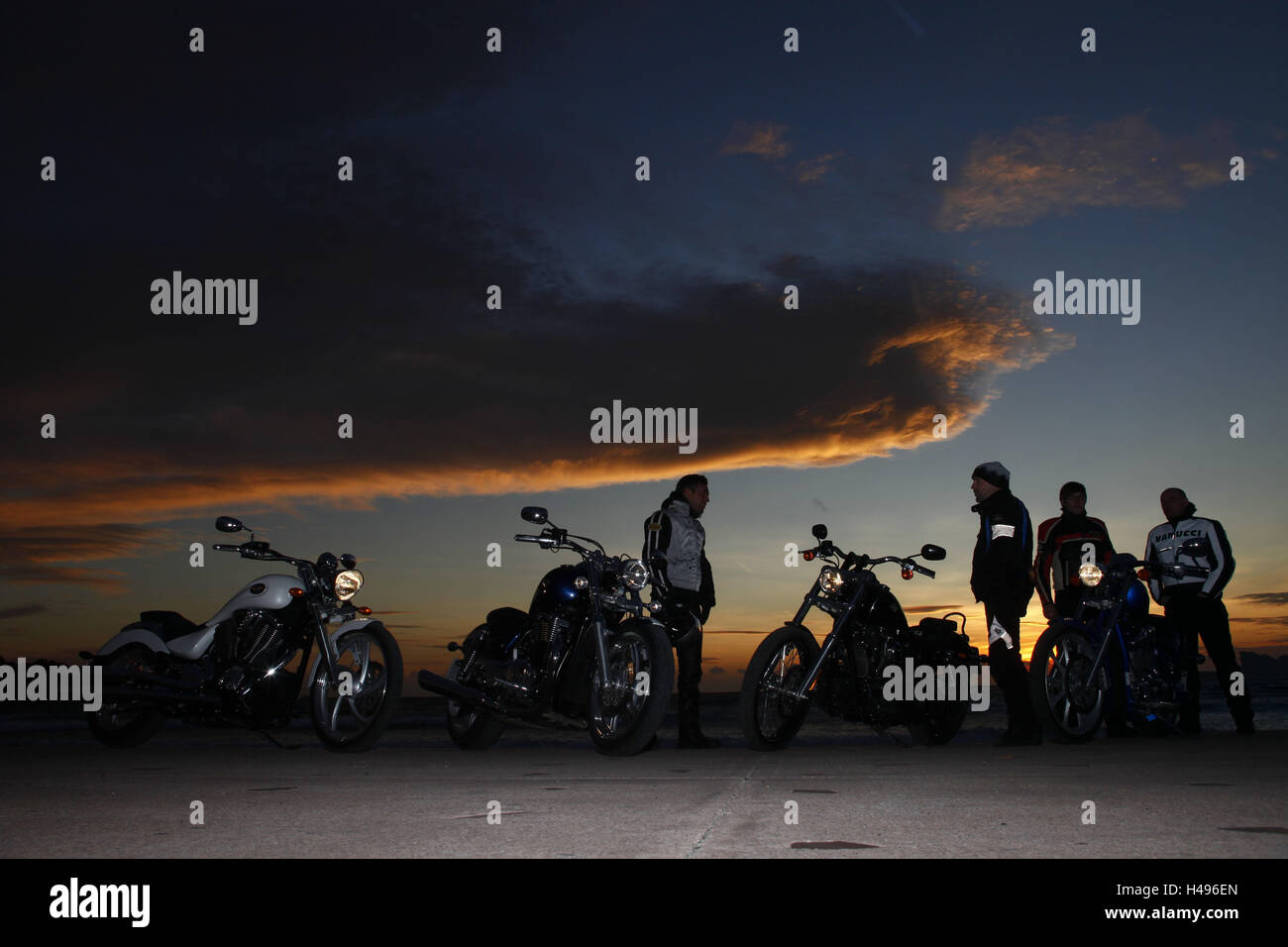 four motorcycles, Cruiser, drivers, vertical, sundown, Stock Photo