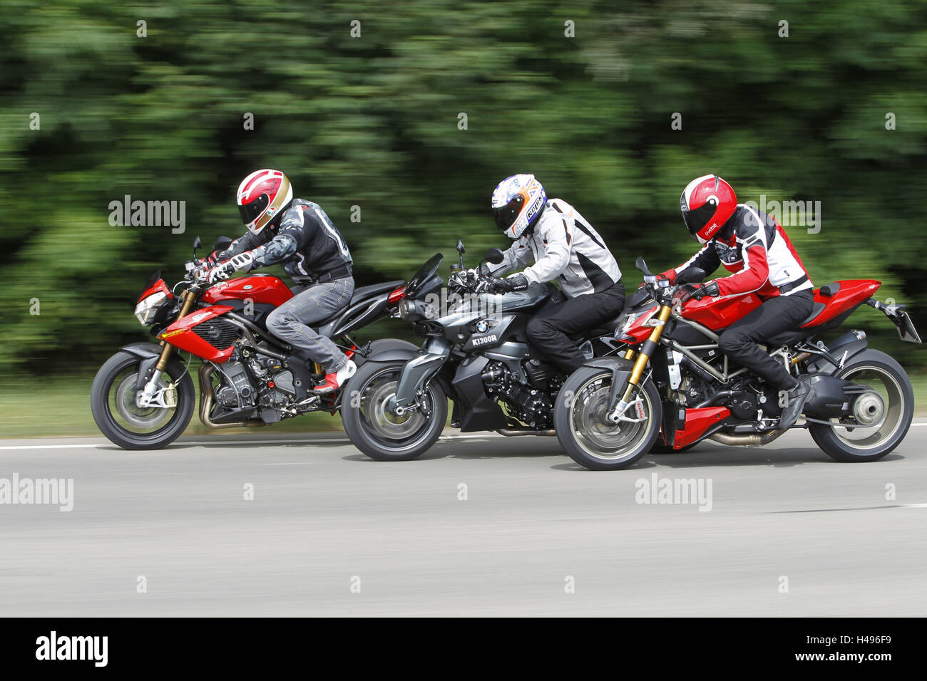 Motorcyclist, motorcycle, dolly shot, fun bikes, 3rd group, panning in front of wood, Stock Photo