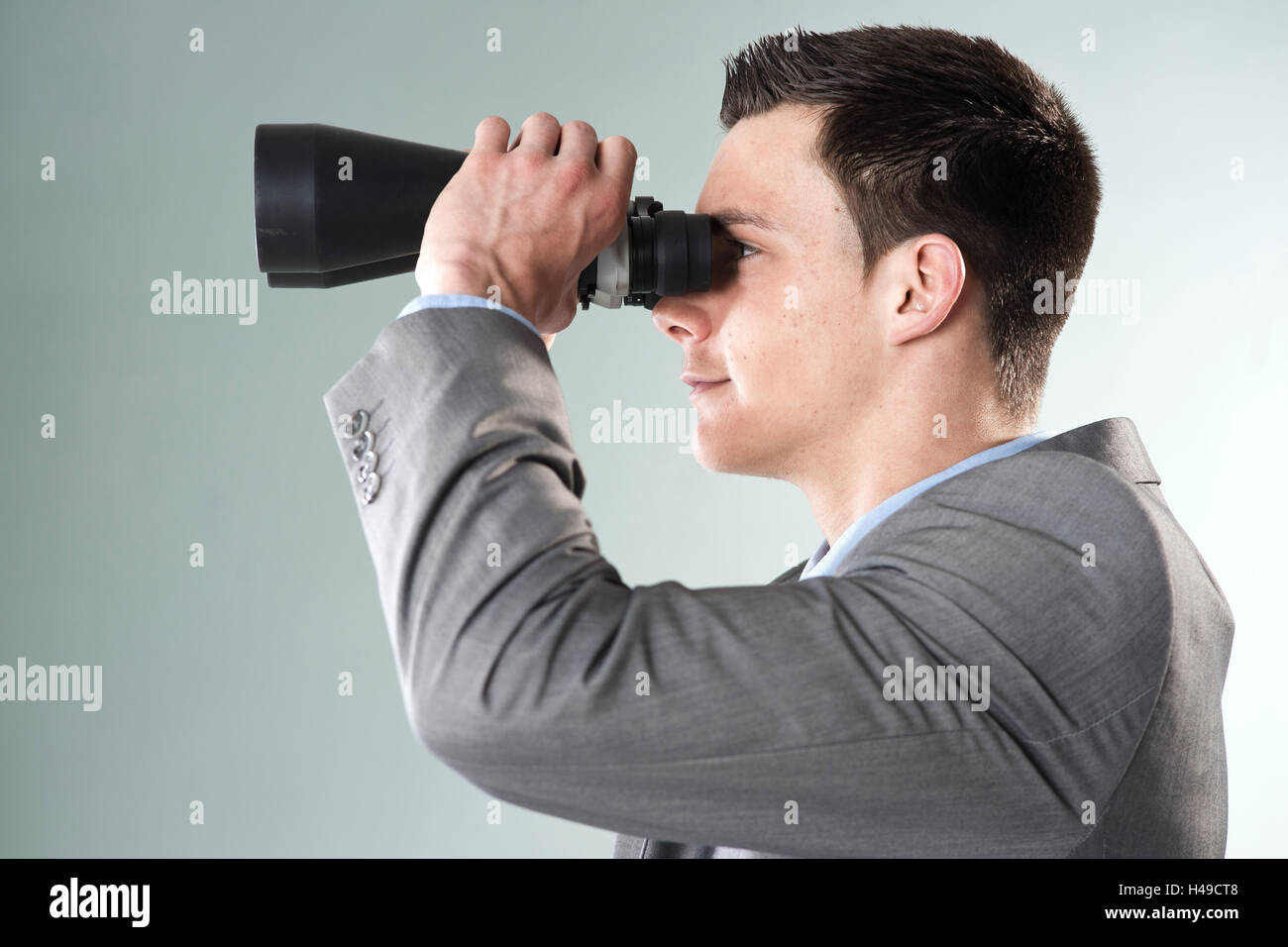 Young entrepreneur looks by binoculars, Stock Photo