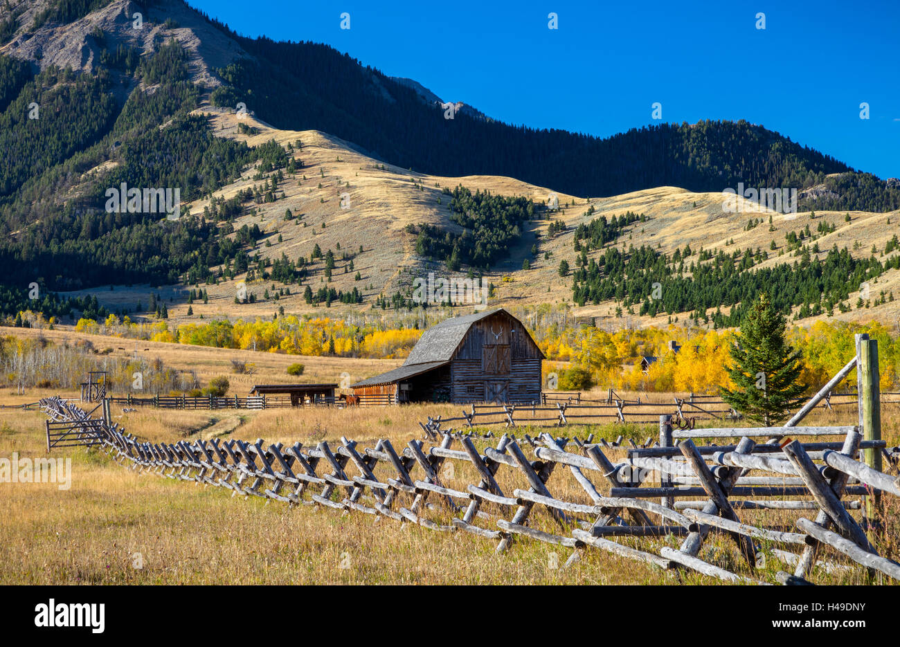 Park County, MT: Wood fence line and barn under the Gallatin Range in fall. Stock Photo