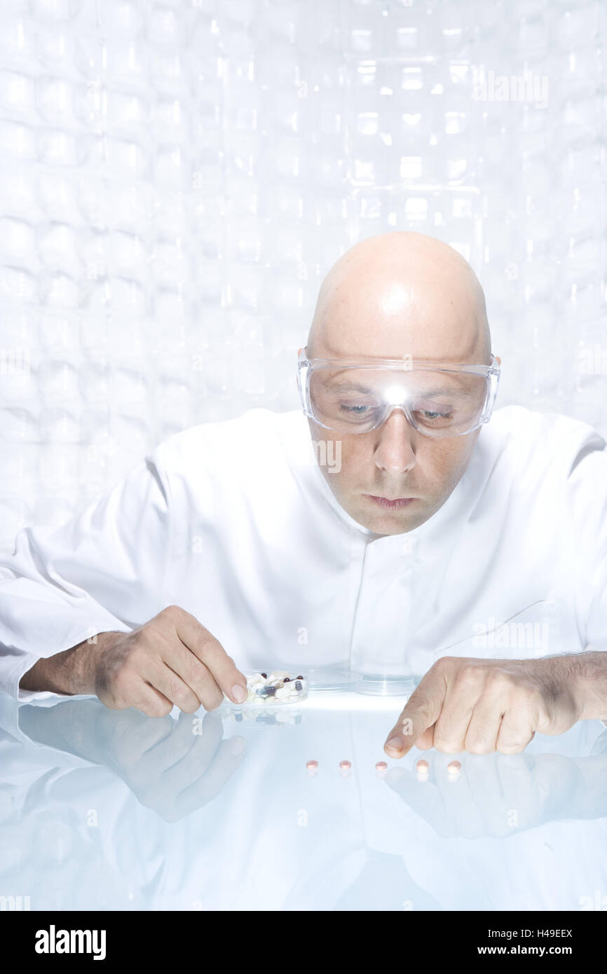 Laboratory, scientist, tablets, look, compare, concentrates, research, science, pharmacology, medicine, person, man, researcher, laboratory assistant, pharmacologist, chemist, doctor, glatzköpfig, bald head, safety glasses, table, sit, drugs, examination, analysis, conception, peels, Peter's peels, portrait, inside, colour mood, colour white, Stock Photo