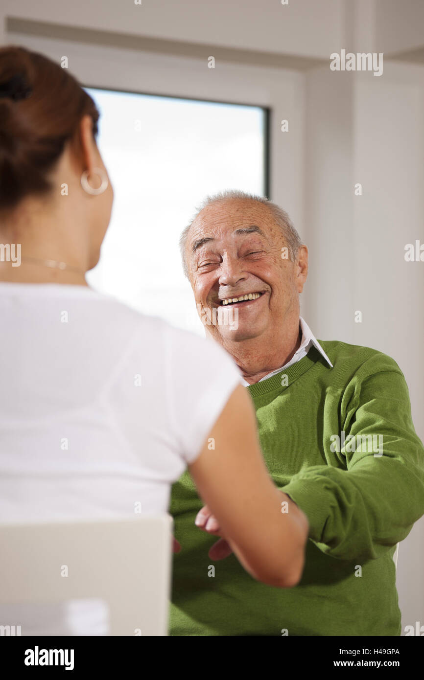Senior man is supplied at home by his daughter, Stock Photo