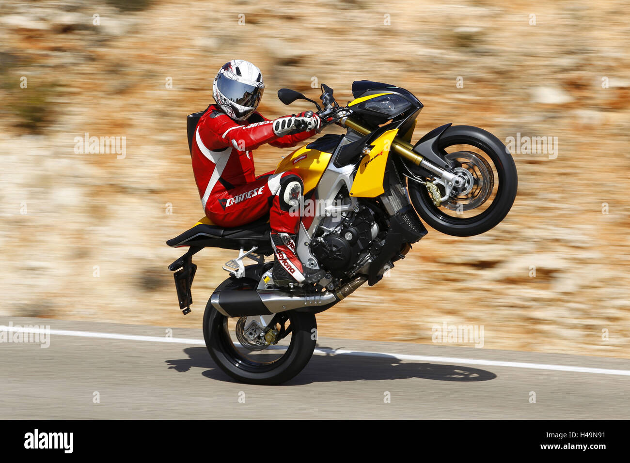 Motorcyclist, Aprilia Tuono V4R, right side, wheelie, blurred motion, Stock Photo