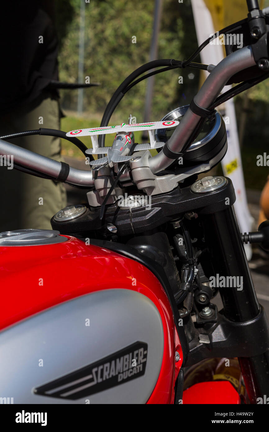 Toy biplane strapped to the handlebars of a Ducati scrambler motorcycle Stock Photo