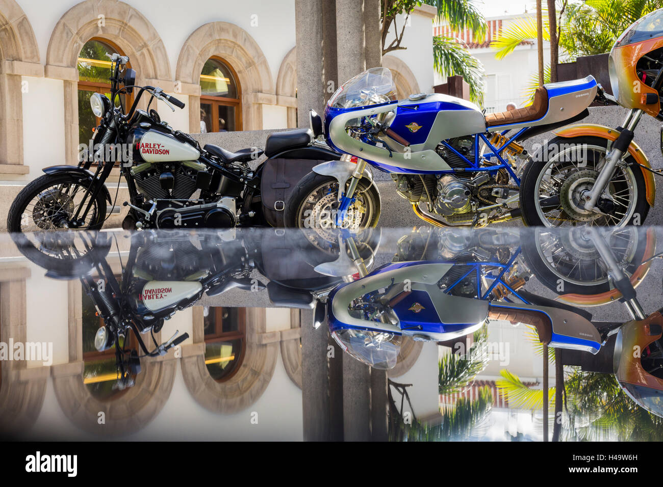 Harley Davidson and ducati desmo reflected in a glass table top at the Mencey Hotel in Santa Cruz de Tenerife for the start of the Queens Cavalcade event, during which 91 motorcycles will spend 4 days completing various routes throughout the Canary Islands. Stock Photo
