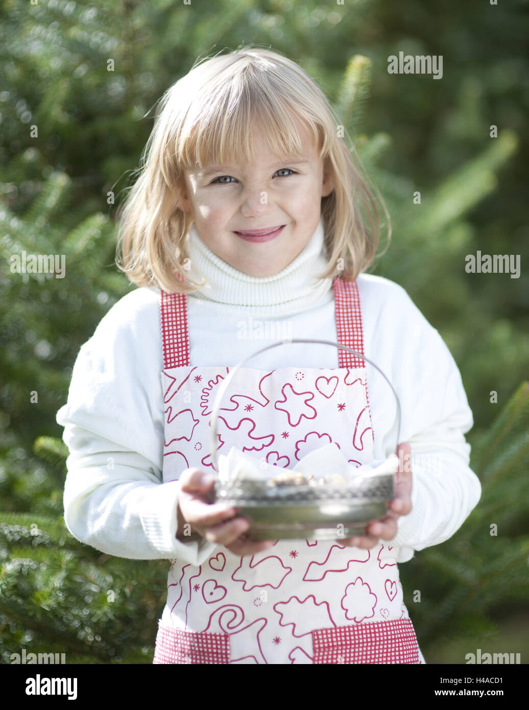 Girl with apron holds silver peel, half portrait, Stock Photo