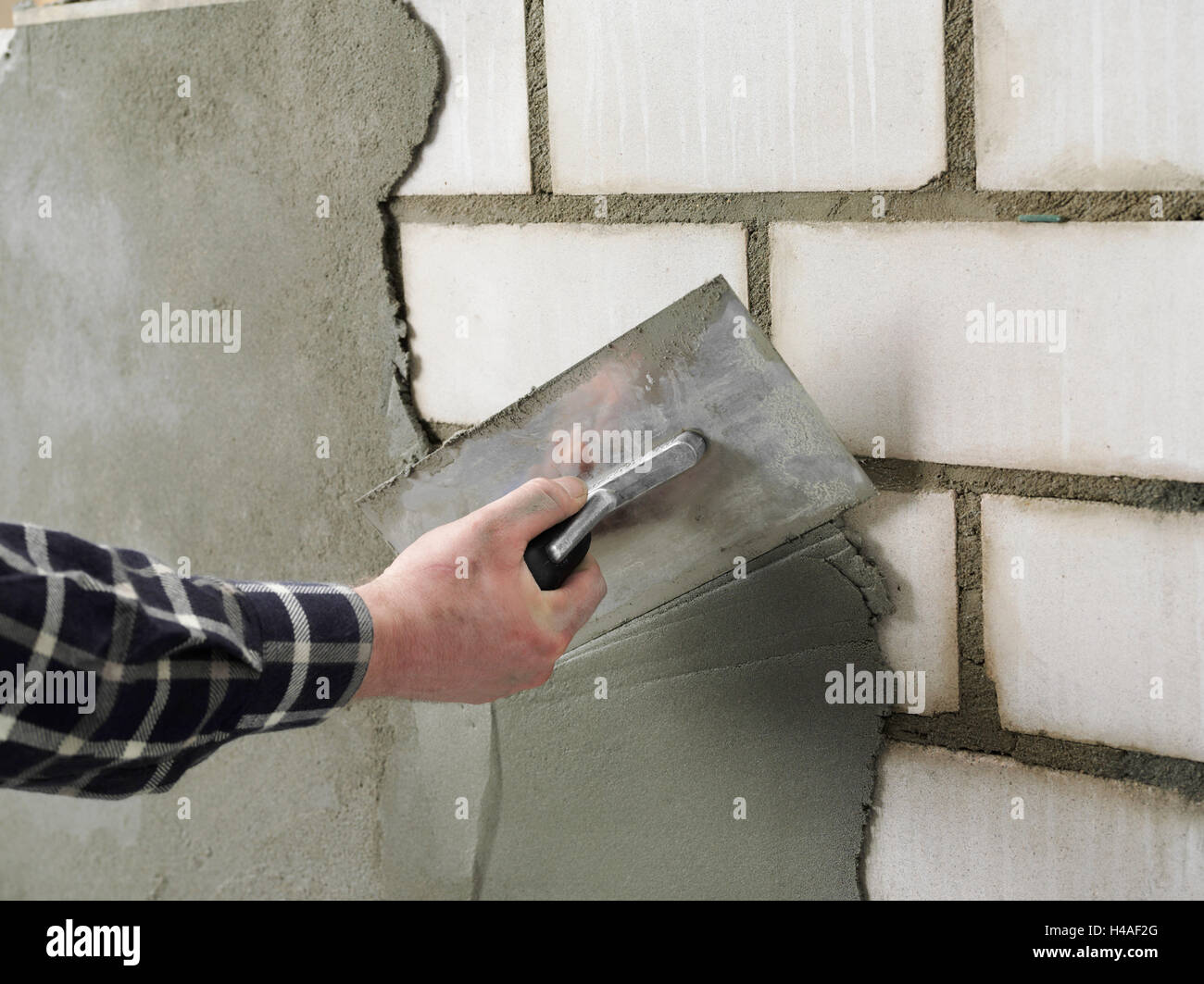 Building site, shell construction, man, hand, wall, plaster Stock Photo