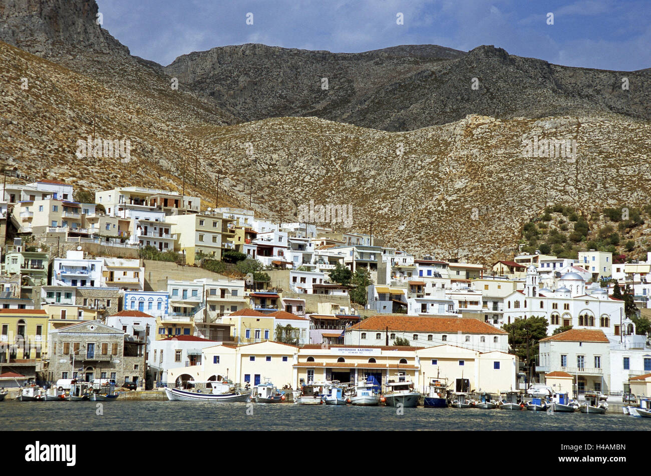 Greece, Dodekanes, island Kalymnos, coast, Pothia, town view, harbour, promenade, boots, mountains, sea, island group, Mediterranean island, the Aegean Sea, seashore, coastal town, island capital, port, bay, architecture, houses, brightly, harbour promenade, fish auction hall, fishing boats, mountains, scanty, two-pronged mattock, Stock Photo
