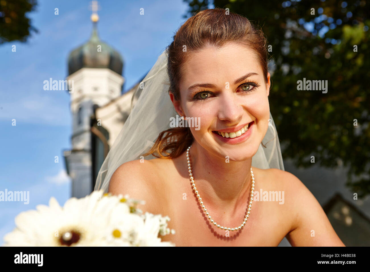 Bride with bridal bouquet in front of church Stock Photo - Alamy