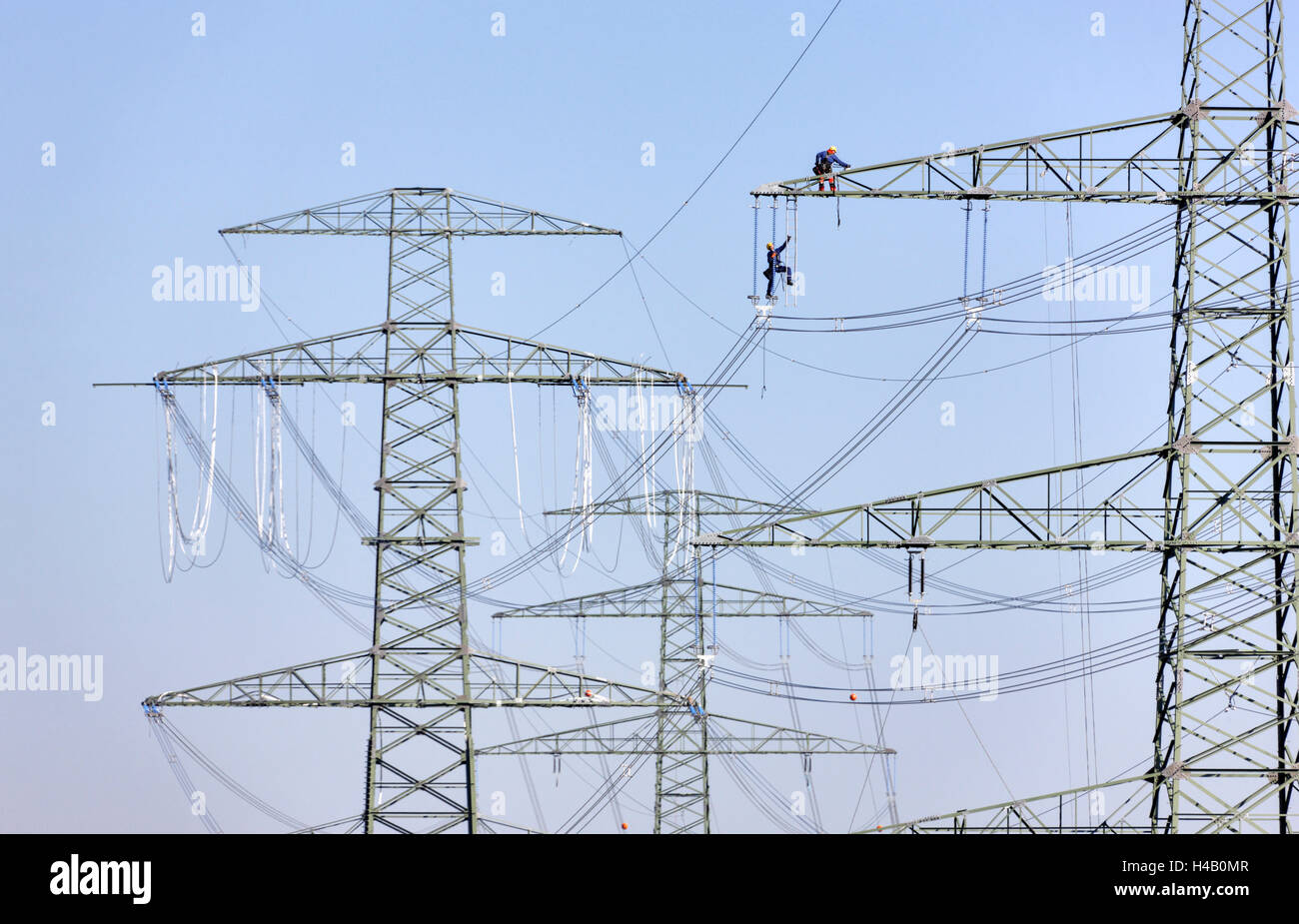 High-voltage poles, power line installation, power supply lines, men, ascent, working on side arm, Thuringian Forest Stock Photo
