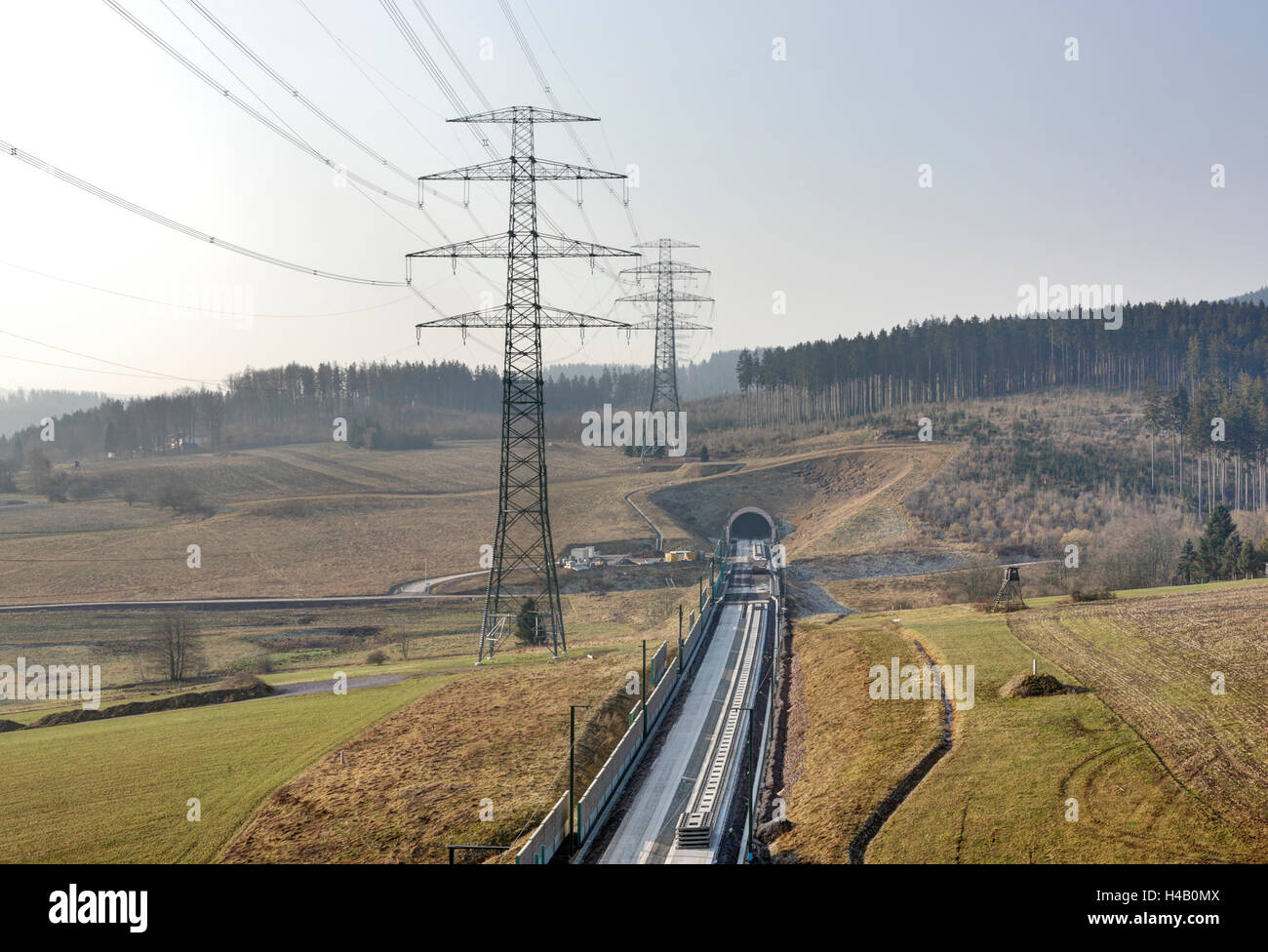 High-voltage poles, forest, tunnel, railroad line under construction, new stretch of track, Thuringian Forest Stock Photo