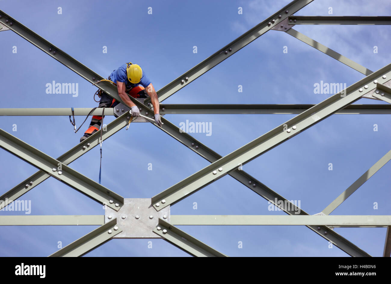 Man assembling a steel brace on a high-voltage power pylon, Thuringian Forest Stock Photo