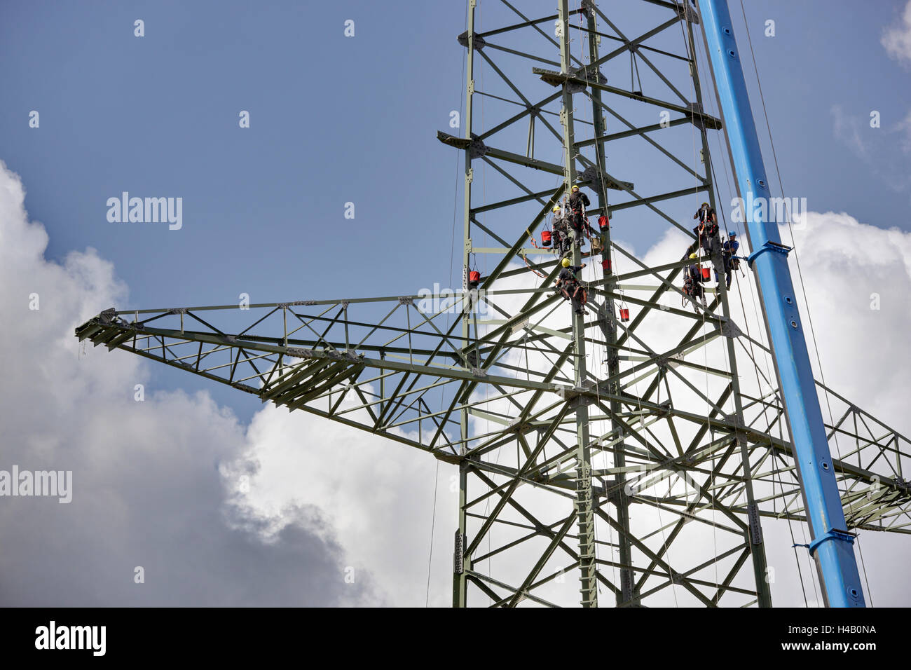 Men working in high-voltage power pylon, Thuringian Forest Stock Photo