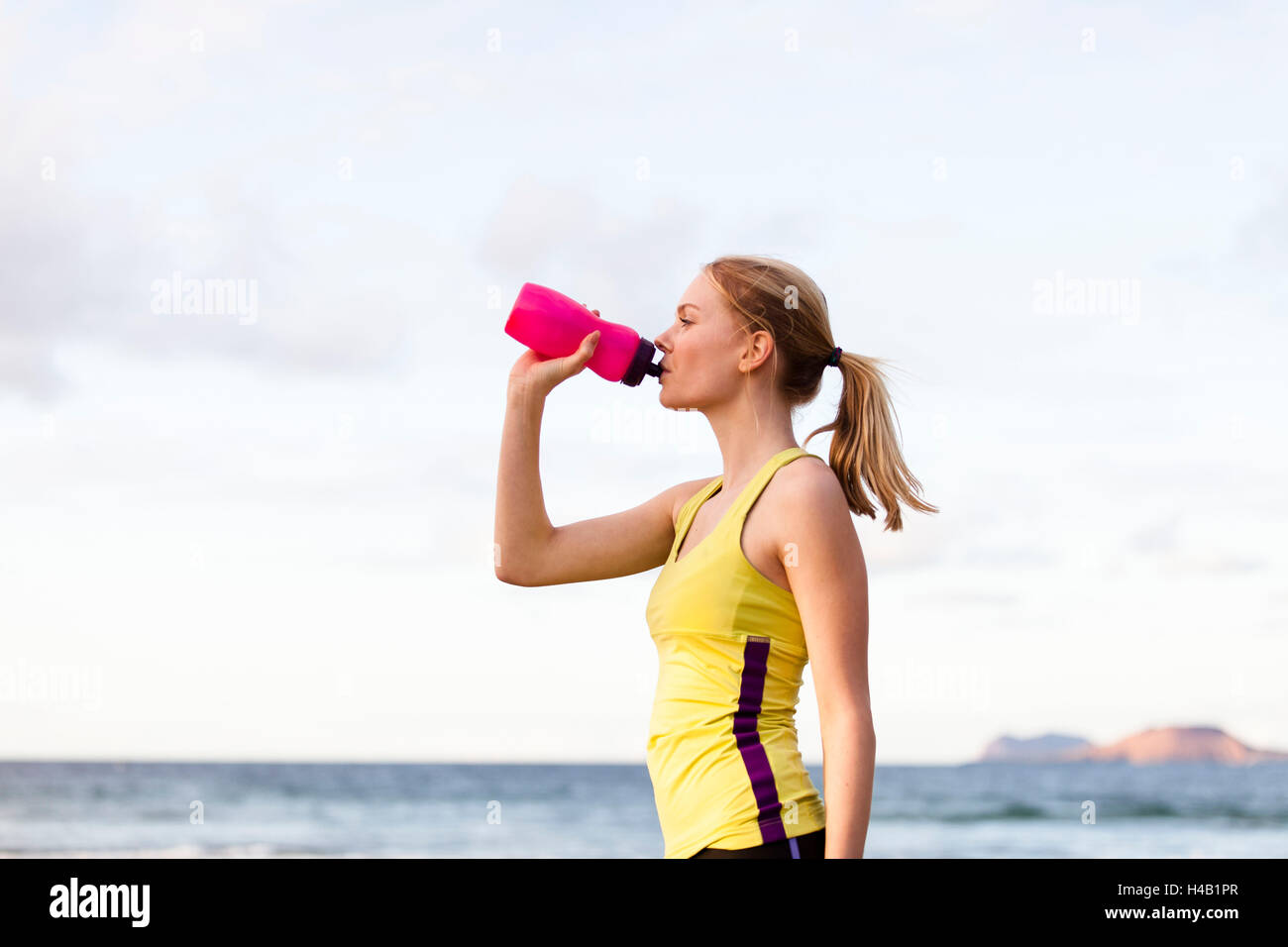 young woman drinking after jogging Stock Photo Alamy