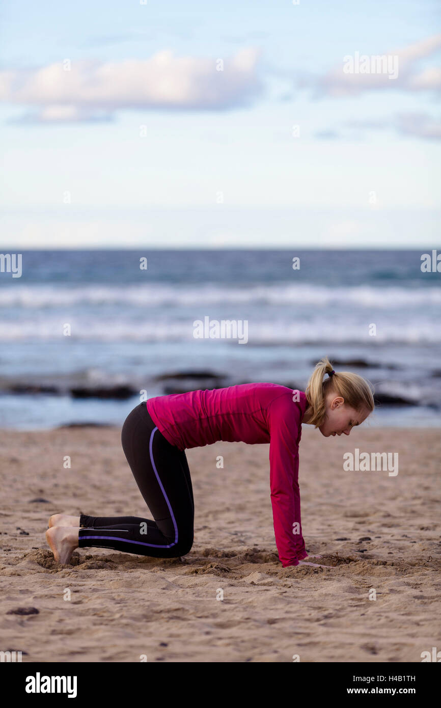 Young woman kneeling beach hi-res stock photography and images - Alamy
